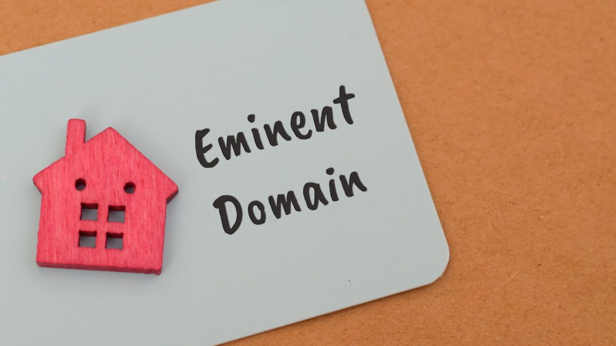 Eminent Domain written next to a red wooden house