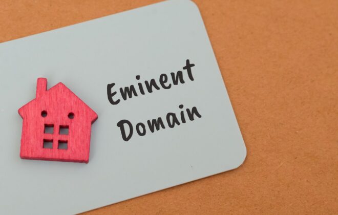 Eminent Domain written next to a red wooden house